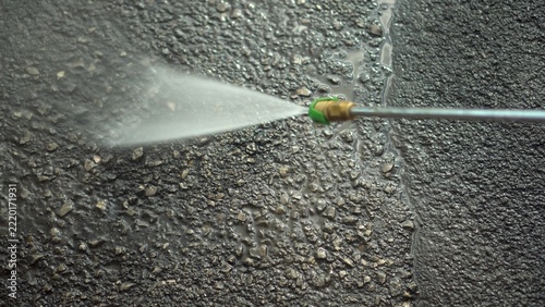 Pressure Washer Cleans Asphalt With a Powerful Water Jet. Side View of a Specialized Water Gun.