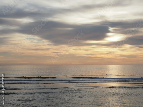 cloudy sunrise on Ogunquit beach in Maine with surfers