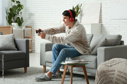 Gaming and entertainment, young man playing video games with controller and h...