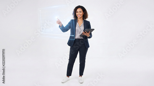 Confident businesswoman wearing navy suit pointing at futuristic holographic graph interface holding tablet
