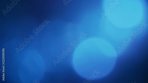 Soft blue bokeh lights gently pulsing in a cinematic dark background for mood and atmosphere