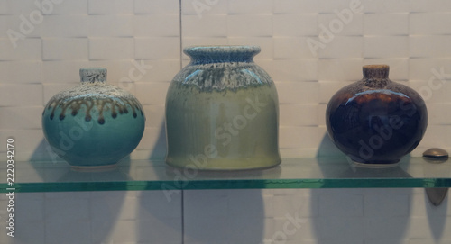front view antique two ceramic vase and one ceramic pot on a glass shelf, white marble wall background, object, decor, fashion, copy space