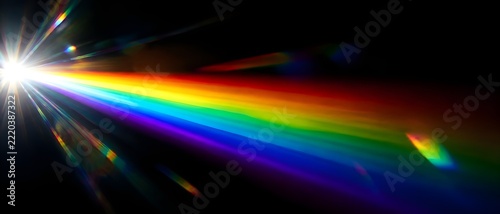 Rainbow prism flare spreading from brilliant white source on black backdrop