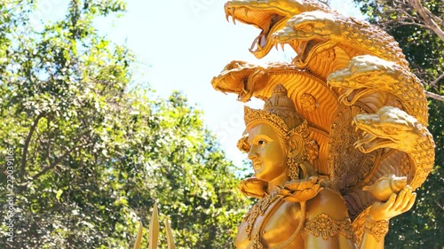 Slow Motion Zoom Out Shot of Golden Lord Vishnu Statue in Public Park