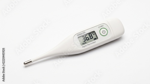 A white digital thermometer lying on a plain white background