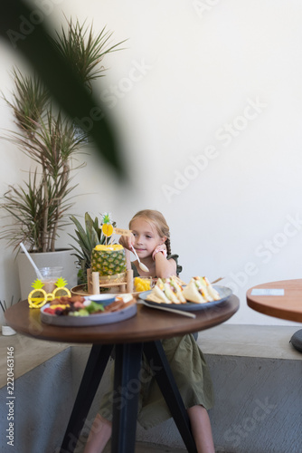 Cute toddler enjoying cake at festive indoor party