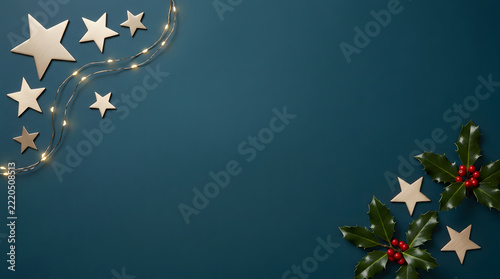 Christmas holiday background with golden stars and holly berries on dark teal festive flat lay