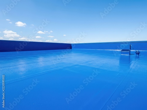A vibrant blue, waterproof coating covers this flat roof, protecting the entire structure from moisture with a reflective and durable finish, maintenance, waterproof, flat