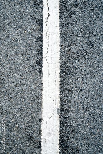 Close-up view of cracked white line on asphalt road surface