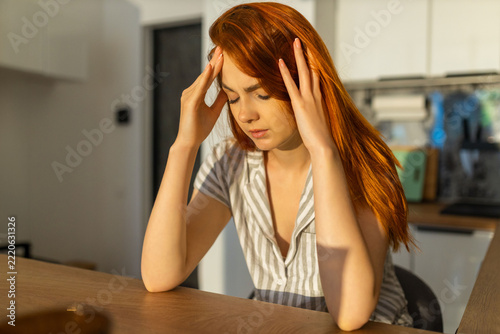 Woman with a Headache Holding Her Temples with Both Hands at Home.