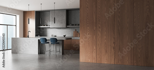 Modern walnut kitchen interior design with concrete island, blue bar stools, pendant lighting, and expansive urban window. 3D Rendering