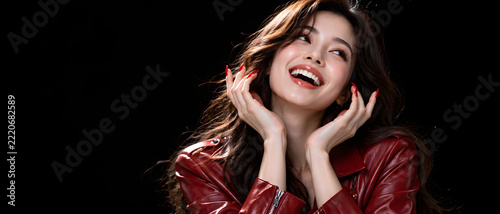 Happy Asian woman, beauty and fashion in red leather jacket on black background for advertising, marketing and retail. Portrait, smile and style with copy space for skincare or commercial media.