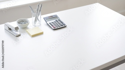 White desk with stapler calculator pens and sticky notes office supplies