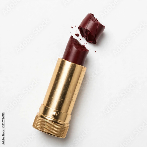 Broken Dark Red Lipstick in Gold Tube on White Background