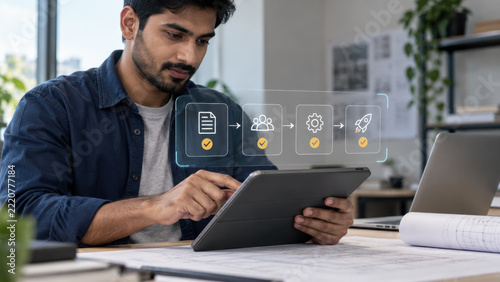 Man planning project workflow with tablet at modern office desk