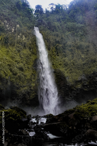 a waterfall in the middle of forest with rushing water