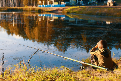 Young Boy Fishing in a Pond at Sunset