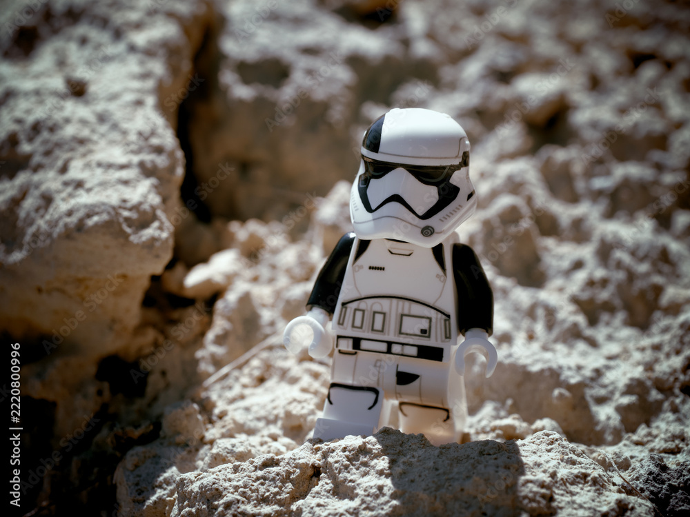 Naklejka premium Chernihiv, Ukraine, July 13, 2021. A minifigure of an imperial stormtrooper from Star Wars against a background of sandy terrain. Illustrative editorial.