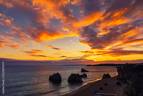 Picturesque sunset on the beach Praia dos Três Castelos, with limestone cliffs, in Portimao, Algarve region, Faro District, Portugal