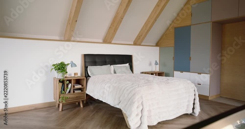 Camera pulling back from glass rail advancing and centering queen bed showing textured comforter