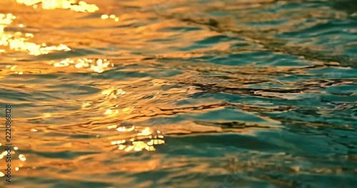 Sunlight sparkling on gentle water ripples, golden reflections