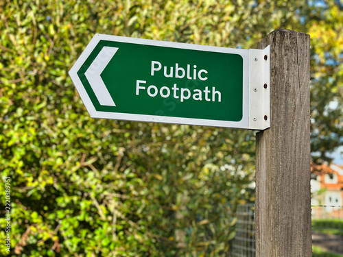 British Green Public Footpath Directional Sign on Wooden Post