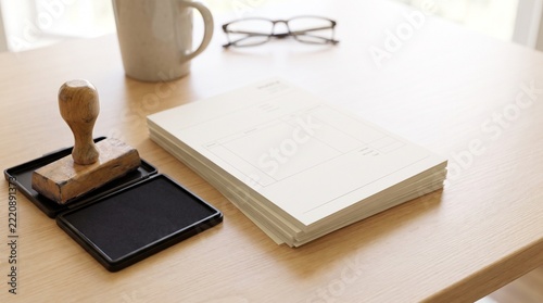 Wooden rubber stamp with ink pad and blank invoices on office desk