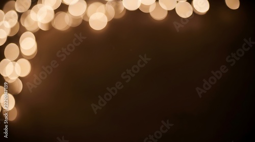 Warm gold bokeh lights frame layout on dark brown background festive holiday texture