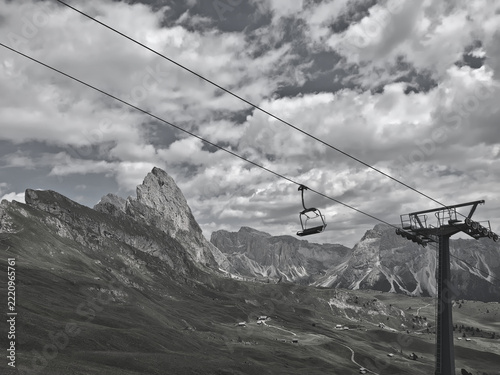 Scenic monochromatic view of a solitary chairlift amidst the beautiful rocky Dolomites