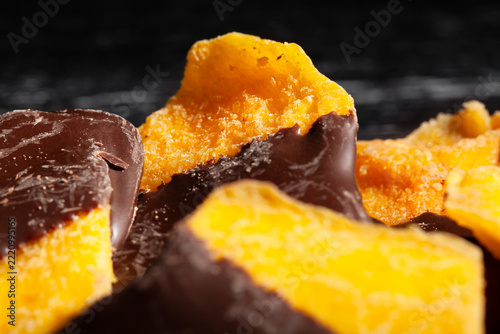 chocolate dipped mango on black wood background