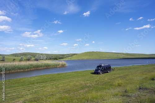 A van parks on a calm lake under a blue sky, camper, motorhome, lake near Coştangalia, Cantemir district, Republic of Moldova, Moldova