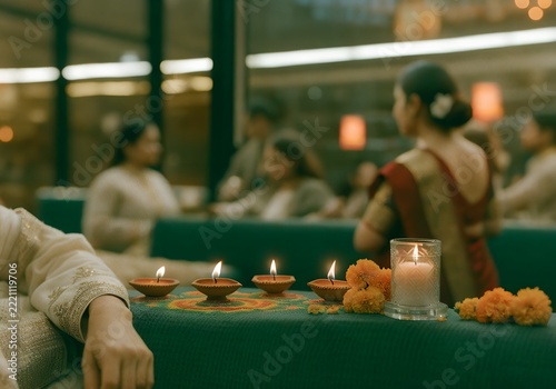 Diwali festival celebration with burning diya oil lamps flowers and blurred family background