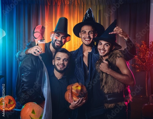 Friends Celebrating Halloween Party with Colorful Cocktails and Jack O Lantern Decorations