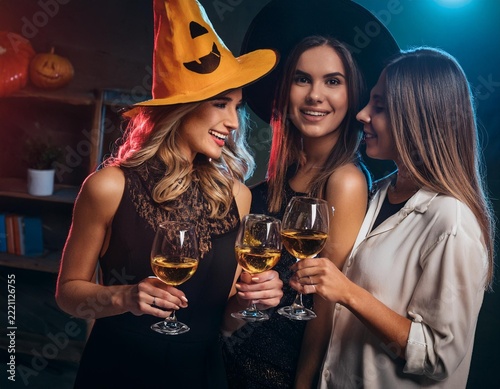 Friends Celebrating Halloween Party with Colorful Cocktails and Jack O Lantern Decorations