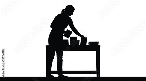Woman silhouette organizing books neatly on top of wooden desk inside bright room interior