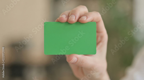 Empty green rectangular card held between fingers for professional identification badge design or custom business card projects.