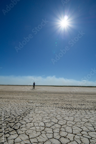 Tourist out on dry cracked mudflats at Derby