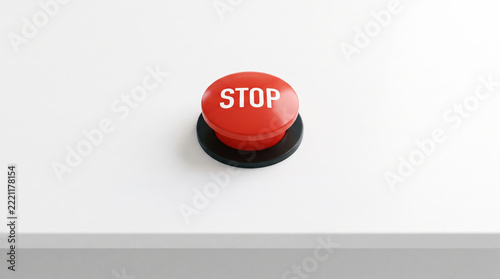Red stop button on desk with bold white lettering and dramatic shadow