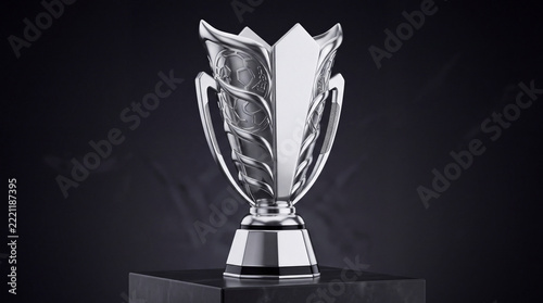 Modern silver trophy cup standing on a dark pedestal representing victory, championship, and success