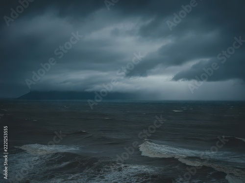 Stormy clouds over calm ocean waves on a beach