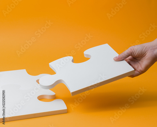 Hand Connecting White Jigsaw Puzzle Piece for Business Solution Concept