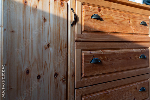 Hand made pine wood chest of drawers, morning light entering the scene.
