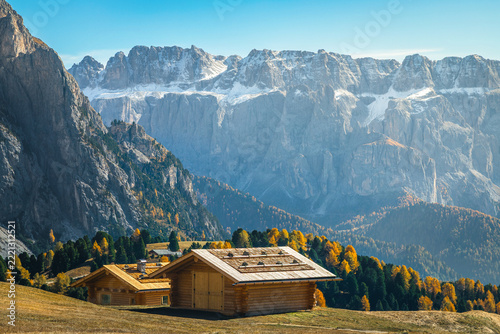 Wooden huts and autumn larch trees in the Dolomites, Italy