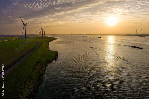 Wind turbines and boats at sunrise over Volkerak in Netherlands