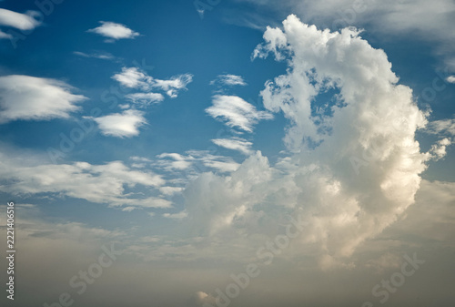 Fotografie Dramatic clouds in a vibrant blue sky during a tranquil afternoon