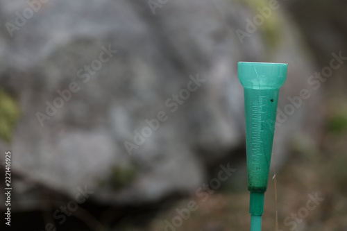 Green Plastic Rain Gauge in a Natural Outdoor Setting