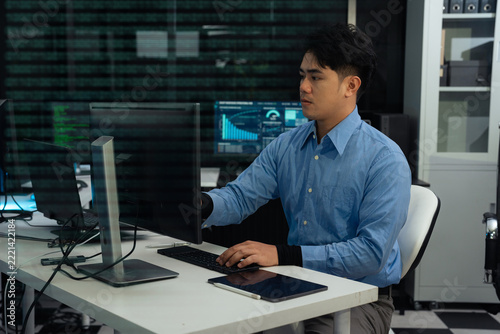 IT specialist tracking network security and data center operation at workstation.