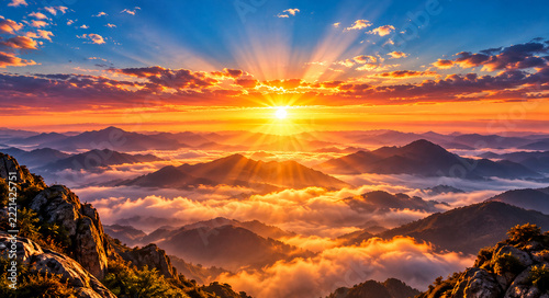 Golden sunrise over mountain peaks with dramatic sun rays and sea of