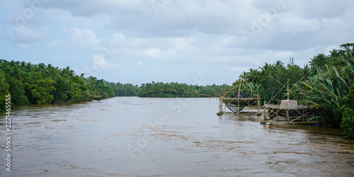Java. Fishing gear in a river surrounded by dense tropical forest