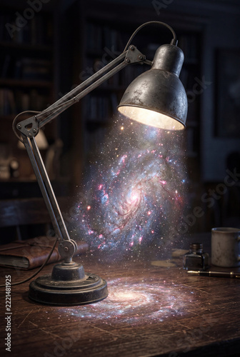 Light shines from a desk lamp revealing a galaxy in a room with books and writing tools